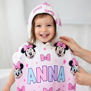 May include: A white ceramic mug with a black handle and the text "But First, Coffee" in a bold, black font. The mug is set against a blurred background, highlighting its clean design.