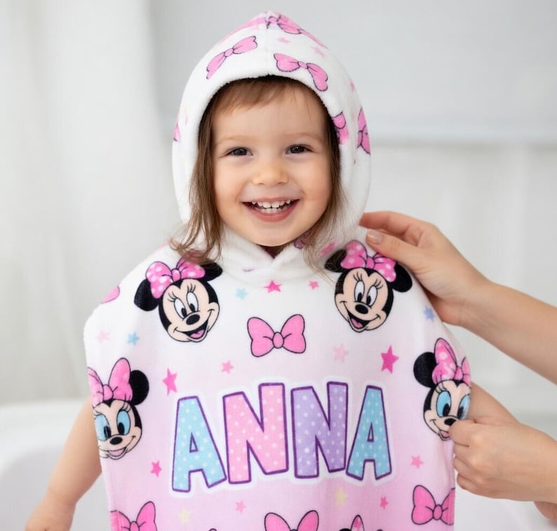 May include: A white ceramic mug with a black handle and the text "But First, Coffee" in a bold, black font. The mug is set against a blurred background, highlighting its clean design.