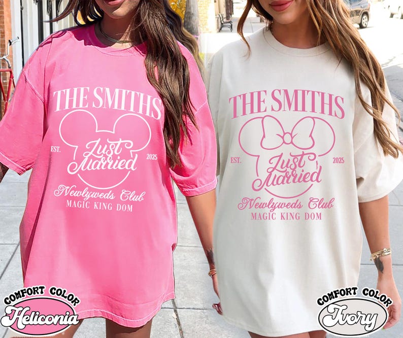 May include: Two oversized t-shirts, one pink and one ivory, featuring a Disney-themed design. The design includes the text "The Smiths," "Just Married," and "Newlyweds Club," with a Mickey Mouse head or bow. The shirts are labeled "Comfort Color."