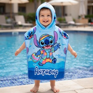 Puede incluir: Una toalla de playa con capucha azul claro con el personaje Stitch de Lilo & Stitch. La toalla tiene un gran gr&aacute;fico de Stitch con una camisa hawaiana y pantalones cortos. El nombre "Anthony" est&aacute; impreso en blanco en la parte inferior.