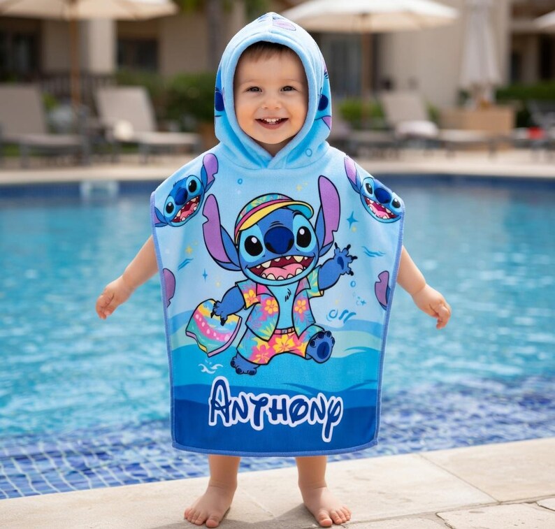 Puede incluir: Una toalla de playa con capucha azul claro con el personaje Stitch de Lilo & Stitch. La toalla tiene un gran gr&aacute;fico de Stitch con una camisa hawaiana y pantalones cortos. El nombre "Anthony" est&aacute; impreso en blanco en la parte inferior.