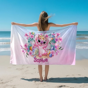 Puede incluir: Una toalla de playa rosa y azul con un personaje de dibujos animados y flores tropicales. La toalla tiene el nombre "Sophia" impreso en ella.