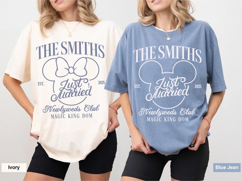 May include: Ivory and blue jean-colored t-shirts with the text "THE SMITHS" and "Just Married" in a Mickey Mouse-inspired design. The shirts also feature "Newlyweds Club" and "MAGIC KING DOM" text. The shirts are short-sleeved.