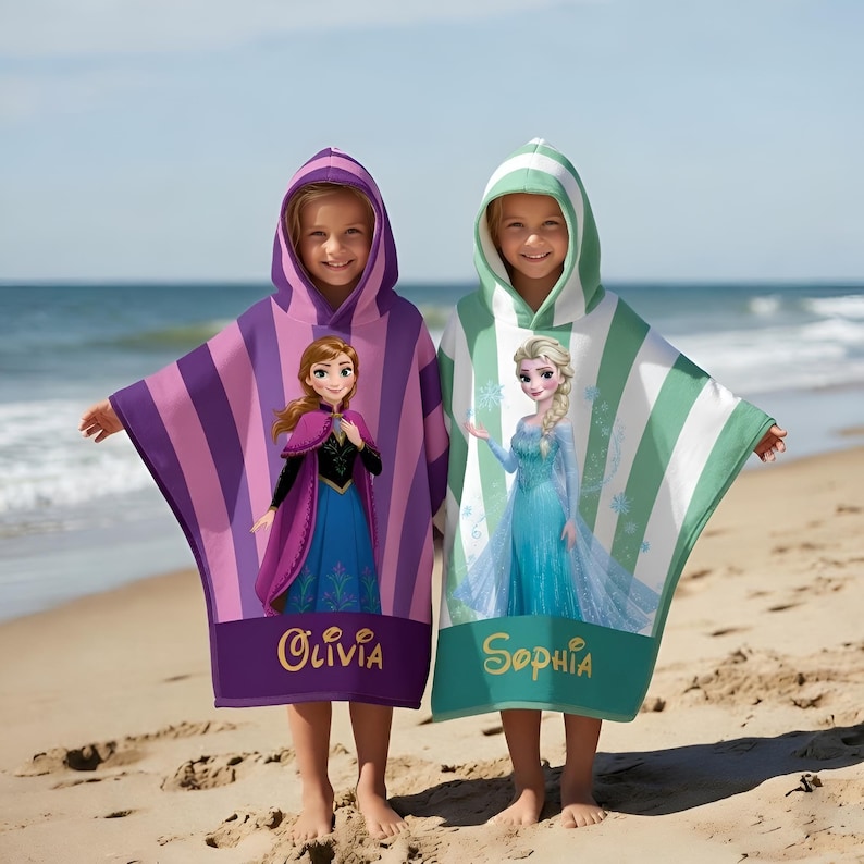 Puede incluir: Dos ponchos de playa con capucha para ni&ntilde;os. Uno es morado con rayas rosas y presenta a Anna, el otro es de rayas verdes y blancas con Elsa. Cada uno tiene un nombre impreso en la parte inferior: Olivia y Sophia.