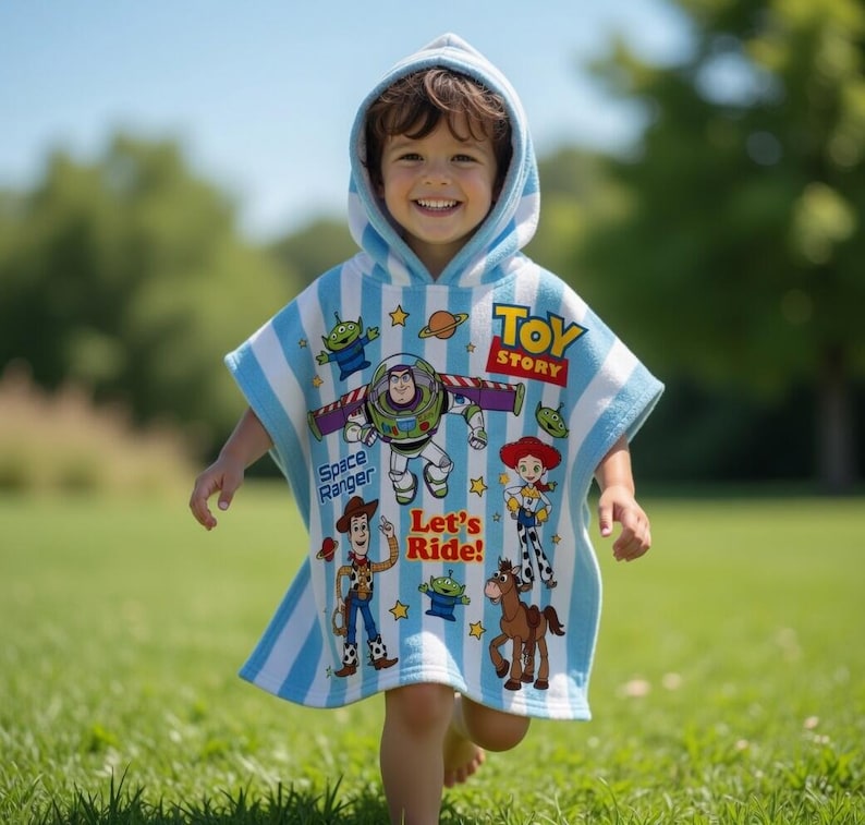 May include: A hooded beach towel featuring characters from the animated film "Toy Story." The towel is light blue with white stripes and has images of Buzz Lightyear, Woody, and other characters. The words "Toy Story" and "Let's Ride!" are also visible.
