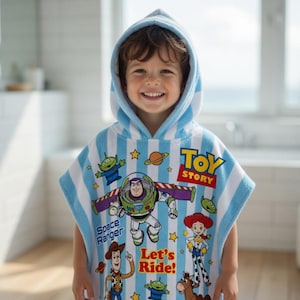 May include: A hooded, blue and white striped towel featuring Toy Story characters. The towel has images of Buzz Lightyear, Woody, and other characters. The words "Toy Story" and "Let's Ride!" are also visible on the towel.