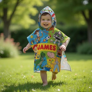 Puede incluir: Un ni&ntilde;o con un poncho con capucha colorido con personajes de Toy Story. El poncho es principalmente azul, verde y amarillo, con el nombre "JAMES" impreso en letras rojas. El ni&ntilde;o sonr&iacute;e y camina sobre hierba verde.