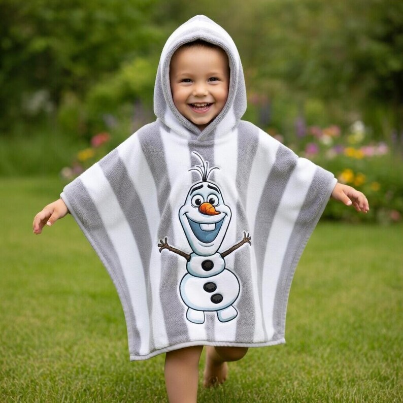 May include: A hooded child's poncho towel featuring a smiling Olaf character from the movie Frozen. The poncho is white and gray striped with a hood and is worn by a child on a green lawn.