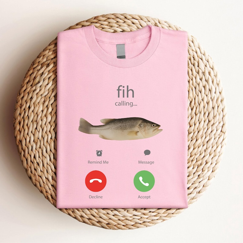 May include: A light pink t-shirt with the words "fih calling..." and a fish graphic. Below the fish are phone icons with the words "Remind Me", "Message", "Decline", and "Accept".