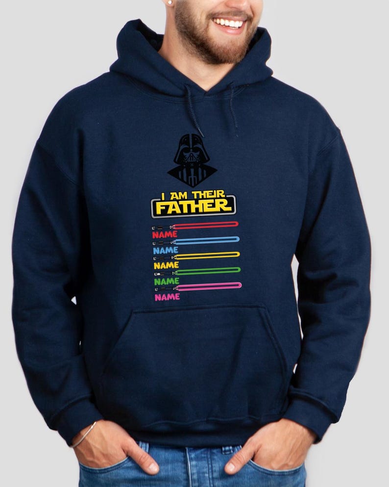 Pu&ograve; includere: Felpa con cappuccio blu navy con grafica di Darth Vader e la scritta "I AM THEIR FATHER". Sotto, spade laser colorate con la parola "NAME" sopra. Un capo d'abbigliamento a tema.