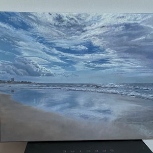 May include: A painting of a beach scene with a cloudy sky and a calm ocean. The beach is sandy and the water is a light blue color. The sky is a light blue color with white clouds.