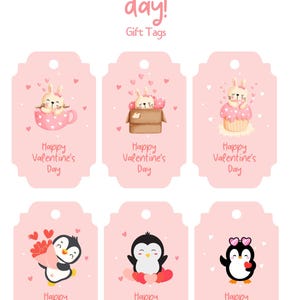 以下が含まれることがあります： 丸みを帯びた角と上部に穴が開いたピンクのギフトタグ6枚。各タグには、ハートと「ハッピーバレンタインデー」の文字が入った、ウサギまたはペンギンの異なるイラストが描かれています。