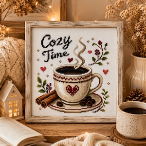 May include: A square cross-stitch embroidery in a distressed white wooden frame featuring a coffee cup with a red heart, cinnamon sticks, and coffee beans. The text reads Cozy Time in black script, surrounded by small red hearts and green leaves.