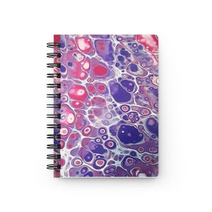 May include: A spiral-bound notebook featuring a cover with an abstract fluid acrylic paint design. The pattern consists of interconnected organic shapes and circular cells in shades of vibrant pink, deep purple, and white, creating a marbled effect.
