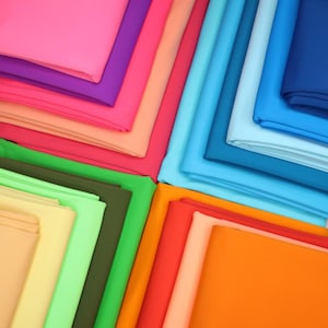 May include: A collection of fabric swatches in various colors, including pink, purple, red, orange, yellow, green, blue, and brown. The swatches are arranged in a symmetrical pattern, creating a visually appealing display.