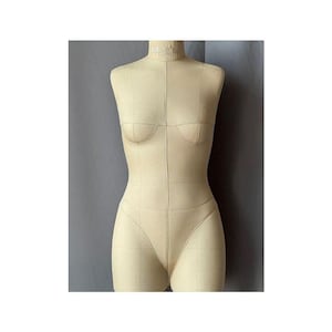Peut inclure: Un mannequin de couture beige, avec une forme de cou, de buste, de taille et de hanches. Le mannequin présente des lignes de quadrillage et est conçu pour la confection de vêtements. Il est en tissu et utilisé pour la couture et le design.