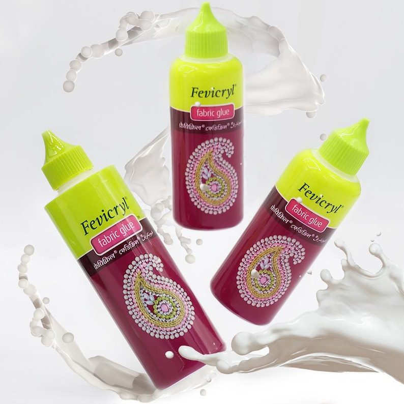Puede incluir: Tres botellas de pegamento para tela Fevicryl con un dise&ntilde;o de cachemira en la etiqueta. Las botellas est&aacute;n rodeadas de l&iacute;quido blanco.