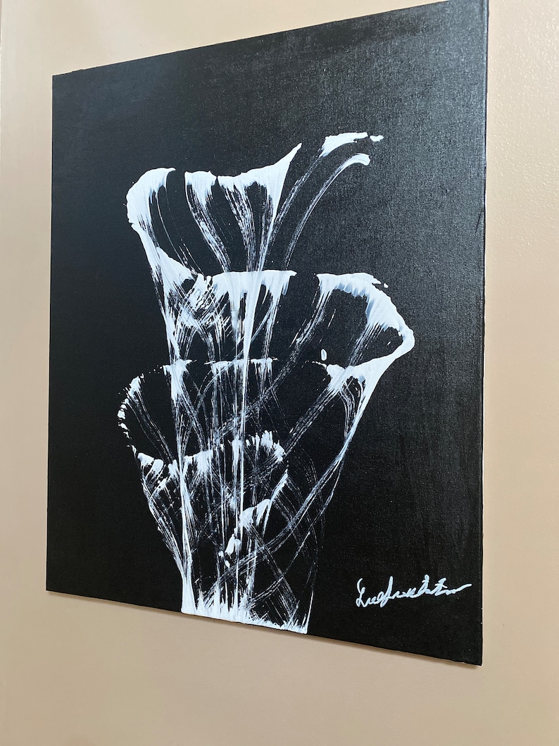 Pu&ograve; includere: Dipinto astratto in bianco e nero di un fiore stilizzato con una firma bianca in basso a destra.