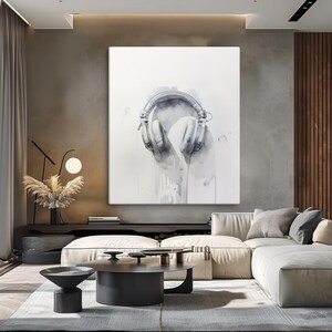 May include: A watercolor painting of white headphones on a white background. The headphones are painted in a realistic style, with details like the earcups and the headband. The background is a soft, light gray, and the painting has a subtle, ethereal feel.