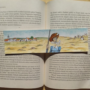 May include: A page from a book about Trappist beers, featuring an illustration of a man in a medieval outfit holding a staff. The text describes the different types of Trappist beers, including Enkel, Dubbel, and Tripel, and explains how the alcohol content is indicated by the number of crosses on the bottle.