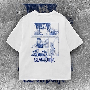 Peut inclure: T-shirt blanc avec des illustrations bleues de style manga de Slam Dunk. Le design comprend des panneaux avec des joueurs de basket-ball et le texte "IT'S NOT TOO LATE TO CHANGE OURSELVES AND HAVE A MEANINGFUL LIFE" et "SLAM DUNK".