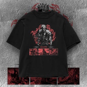 Puede incluir: Una camiseta negra de manga corta con un gráfico central de un caballero con armadura rodeado de patrones de llamas rojas. Debajo de la imagen principal, el texto "DARK SOULS" aparece sobre tres paneles rectangulares con escenas de batalla en rojo.