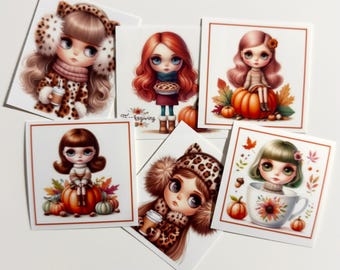 May include: A collection of six square stickers featuring illustrations of wide-eyed characters in autumn settings. Designs include characters with leopard print hats, a red-haired figure holding a pie, and characters sitting on pumpkins or inside a floral teacup.