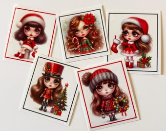May include: Five square cards featuring illustrations of characters with large eyes and brown hair in holiday attire. One shows a Santa hat, another a poinsettia, a third a stocking, a fourth a nutcracker outfit, and the fifth a winter hat.