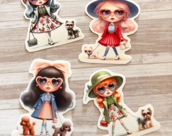 Op de afbeelding: Vier gestanste stickers met gestileerde illustraties van modieuze figuren met hartvormige zonnebrillen en kleine honden. Elke figuur is gekleed in stijlvolle outfits, waaronder hoeden, jassen en rokken, en houdt een riem vast. De stickers liggen op een licht houtnerfoppervlak.