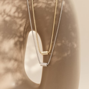 May include: Two silver chains with personalized nameplate pendants. The top pendant reads "David Daniel" and the bottom pendant reads "Christopher Andrew".