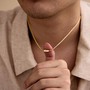 May include: A gold chain necklace with a small rectangular pendant that says "Gemma".