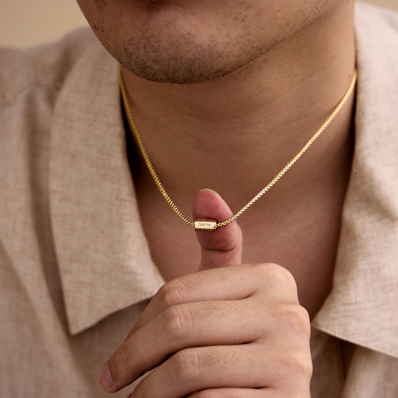 May include: A gold chain necklace with a small rectangular pendant that says "Gemma".