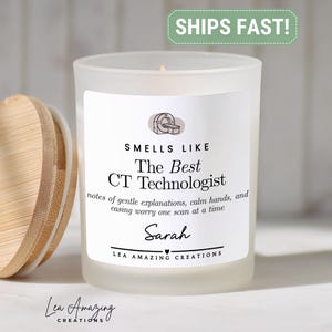 May include: A frosted glass candle with a bamboo lid. The label features a CT scanner icon and text that reads: SMELLS LIKE The Best CT Technologist, notes of gentle explanations, calm hands, and easing worry one scan at a time, Sarah, LEA AMAZING CREATIONS.