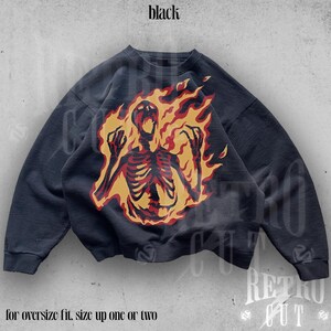 May include: Black sweatshirt with a graphic print of a skeleton engulfed in flames. The text "for oversize fit, size up one or two" is printed below the image.