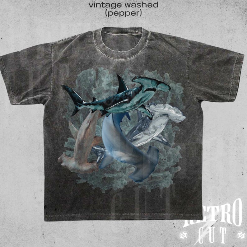 May include: A vintage washed gray t-shirt with a graphic print of four hammerhead sharks in a coral reef. The text "vintage washed (pepper)" is printed at the top of the shirt.
