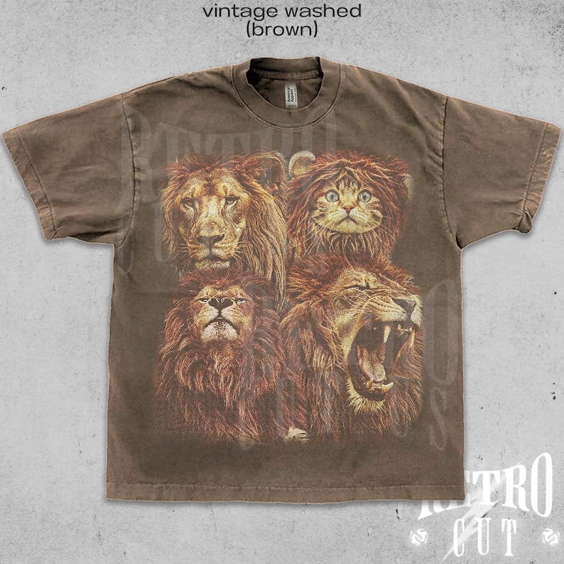 May include: A brown t-shirt with a vintage washed look, featuring a print of four animal faces: a lion, a cat, and two more lions. The cat is wearing a lion mane.
