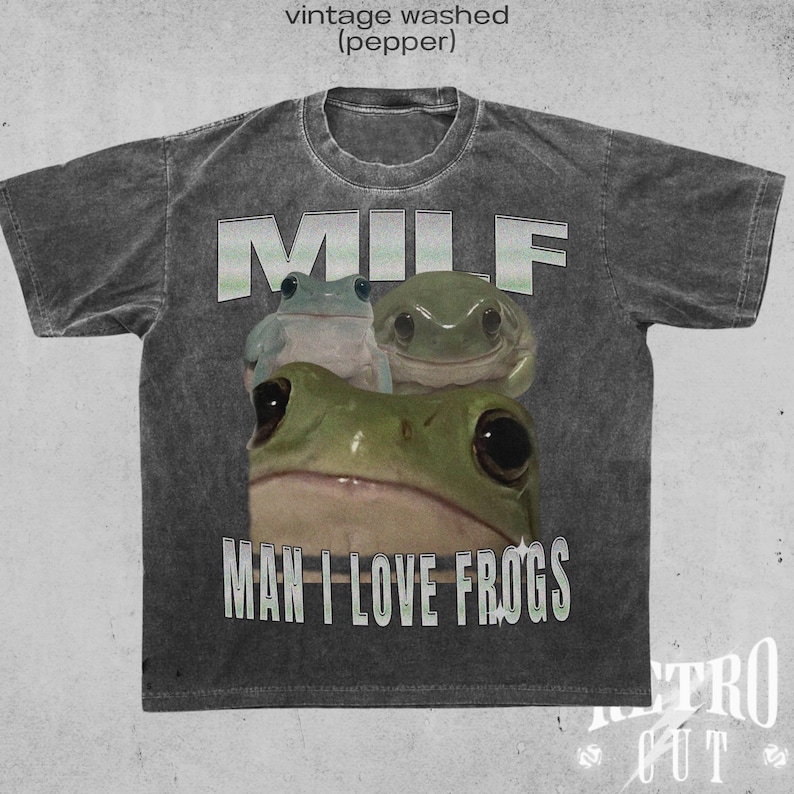 May include: A grey t-shirt with a vintage washed look features the text "MILF MAN I LOVE FROGS" in white. Three green frogs are pictured below the text.