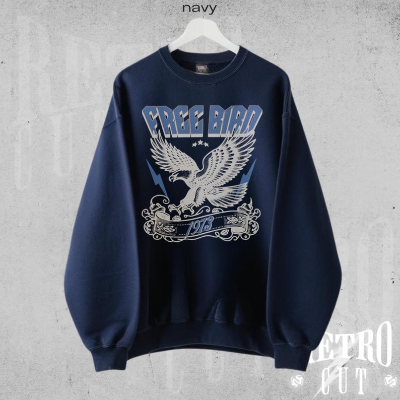 May include: A navy blue sweatshirt with a white eagle graphic and the text "FREE BIRD 1978" printed on the front.