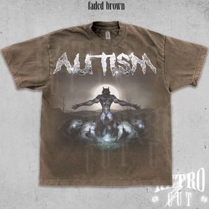 K&ouml;nnte beinhalten: Ein ausgebleichtes braunes T-Shirt mit einem grafischen Aufdruck eines Werwolfs und dem Wort "AUTISM" in silbernen Buchstaben.