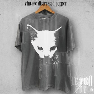 May include: A gray vintage t-shirt with a distressed white cat graphic. The shirt has the text "Retro Cut" printed on the bottom.