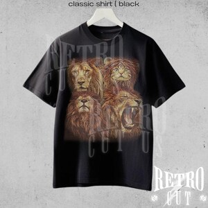 May include: Black t-shirt with a graphic print of four lion faces. The lion faces are arranged in a square pattern. The t-shirt has a crew neck and short sleeves.