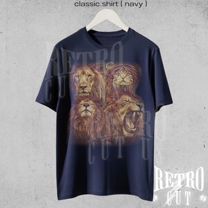 May include: A navy blue t-shirt with a graphic print of four lion faces, including a cat face. The text "Retro Cut" is printed on the shirt.