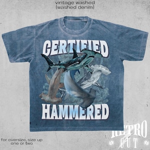 May include: A blue vintage washed denim t-shirt with a graphic of hammerhead sharks and the text "CERTIFIED HAMMERED".