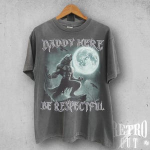 May include: A grey t-shirt featuring a werewolf graphic and the text "Daddy Here Be Respectful".