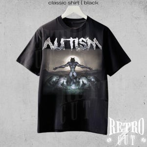 K&ouml;nnte beinhalten: Schwarzes T-Shirt mit einem Grafikdruck eines Werwolfs, der vor einem Vollmond steht. Der Text "AUTISM" ist in Silber &uuml;ber dem Werwolf gedruckt.