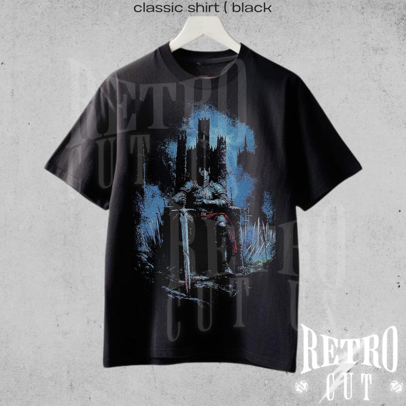 May include: Black t-shirt with a graphic print of a figure sitting on a throne in front of a castle. The text "Retro Cut" is printed on the bottom of the shirt.