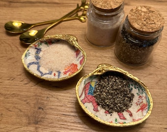 Decoupage, gold rimmed clam shell spice serving dishes with gold spoons. Comes with Himalayan sea salt & cracked black pepper