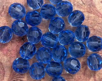 Large 8mm faceted round glass beads in transparent sapphire blue. 1930's vintage glass, made in Germany. 25 piece lot.