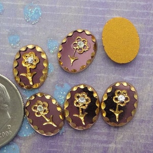 6 petits cabochons vintage de taille 8 x 10 mm en verre violet améthyste avec des accents dorés. Motif marguerite avec strass transparent.