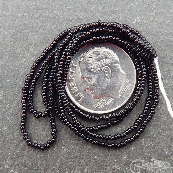 Size 18/0 tiny antique seed beads in opaque black. Late 1800's vintage glass microbeads hank.